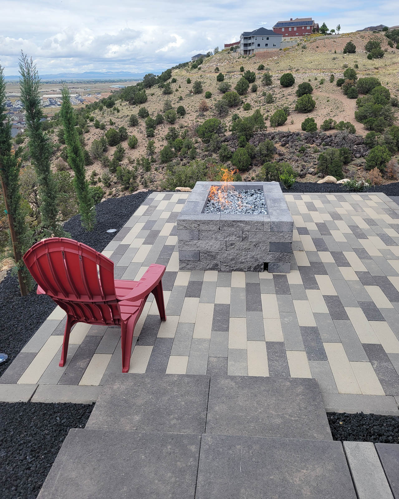Paver patio with stone fire pit overlooking the hills