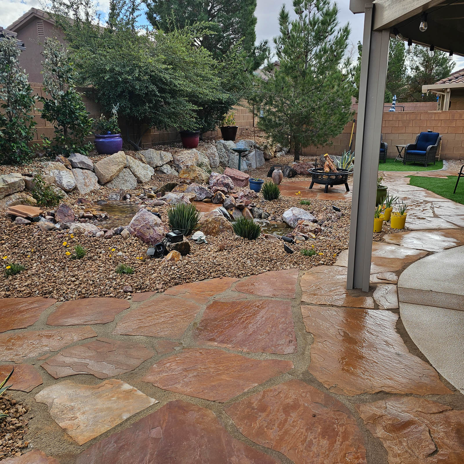 Covered patio opening onto flagstone and rock garden