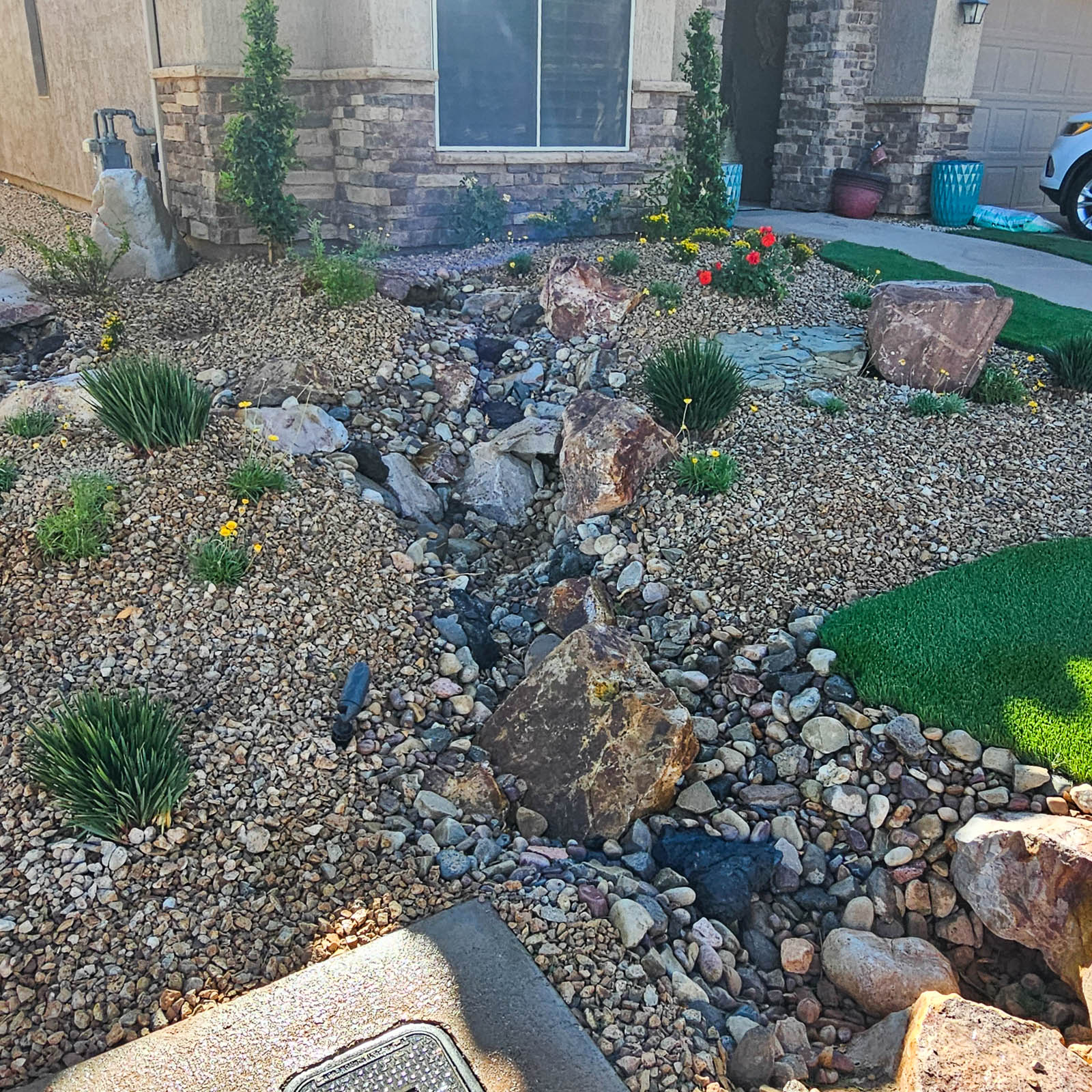 Desert dry creek bed with grasses and boulders
