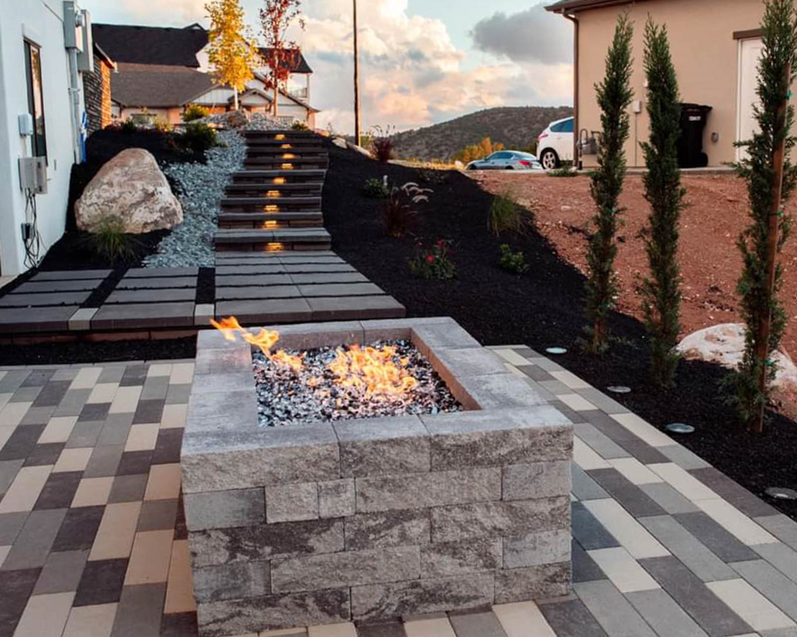 Modern square gas fire pit on a multi-tone paver patio